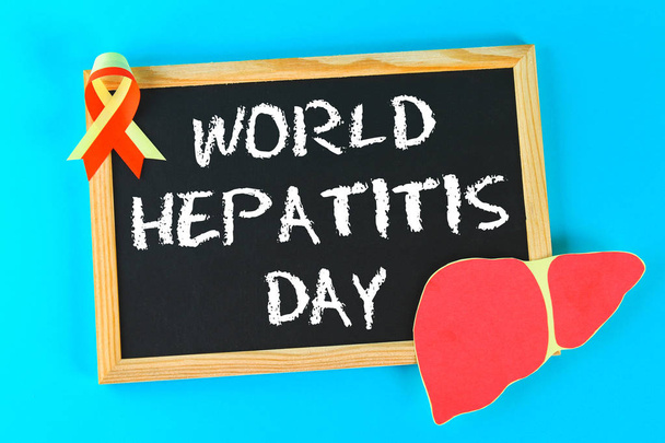 Chalkboard with text World Hepatitis Day. June 28th. Liver and red yellow ribbon on a blue background - Foto, Imagen