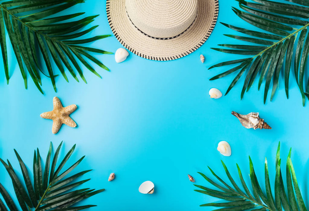 Reiziger accessoires, tropische palmtak takken op blauwe achtergrond met lege ruimte voor tekst. Reizen vakantie concept. Zomer achtergrond. Plat lag, top uitzicht. - Foto, afbeelding