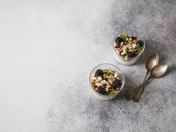 Yogurt with granola, walnut, dates, blackberries and mint in glasses - Foto, Imagem