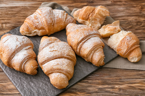 Břidlicové desky s chutnou croissanty na dřevěný stůl - Fotografie, Obrázek