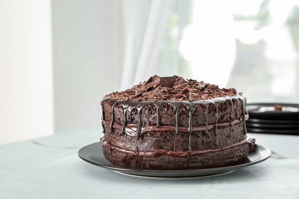 Placa con delicioso pastel de chocolate en la mesa
 - Foto, imagen