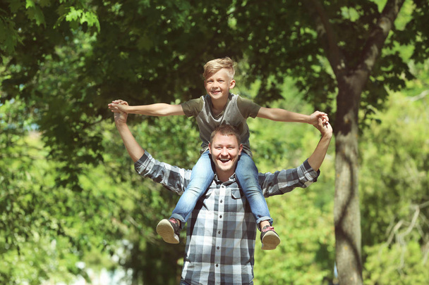 Szczęśliwy ojciec i syn w parku na słoneczny dzień - Zdjęcie, obraz