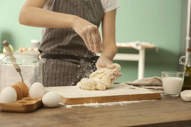 Nainen ripottelemalla jauhot taikina keittiössä
 - Valokuva, kuva