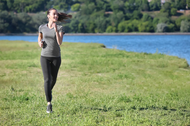 Sportliche junge Frau läuft im Freien - Foto, Bild