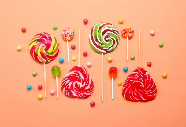 Плоска композиція з цукерками на кольоровому фоні
 - Фото, зображення
