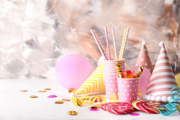 Items van de partijen van de verjaardag met snoepjes op tafel - Foto, afbeelding