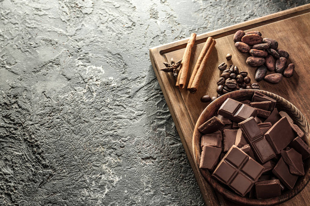 Состав с вкусным молочным шоколадом на сером текстурированном фоне
 - Фото, изображение