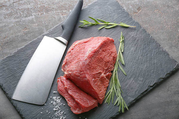 Fresh raw meat with rosemary and knife on slate plate - Photo, Image