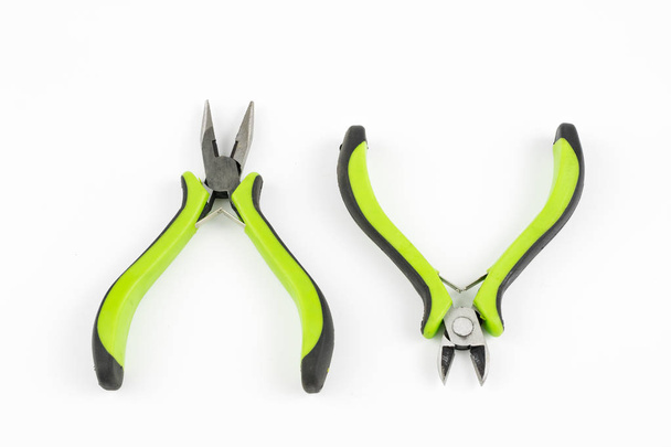 Pliers and cable cutters on a white table. Accessories for DIY enthusiasts and electricians. White background. - Foto, imagen