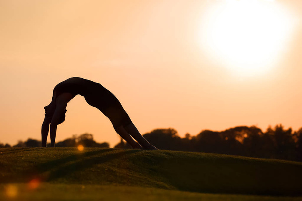 schöne junge Frau, die morgens im Freien Yoga praktiziert - Foto, Bild