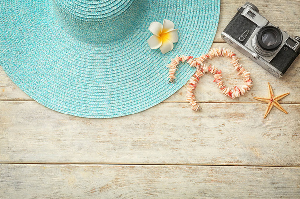 Fotoğraf makinesi ve ahşap zemin üzerine şapka kompozisyonu. Yaz tatili - Fotoğraf, Görsel