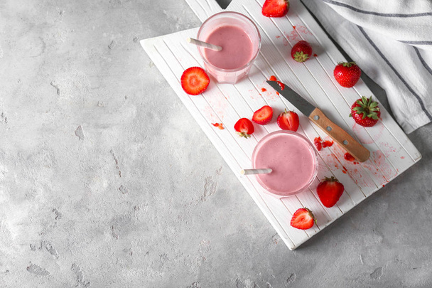 Σύνθεση με ποτήρια νόστιμο smoothie φράουλα στο φως τραπέζι - Φωτογραφία, εικόνα