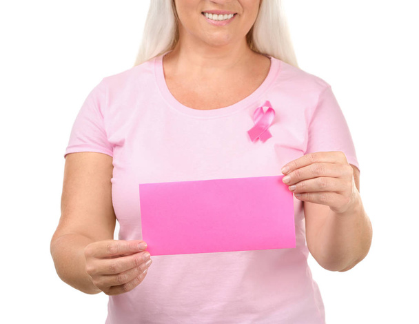 schöne reife Frau mit rosa Schleife hält Karte auf weißem Hintergrund. Brustkrebs-Konzept - Foto, Bild