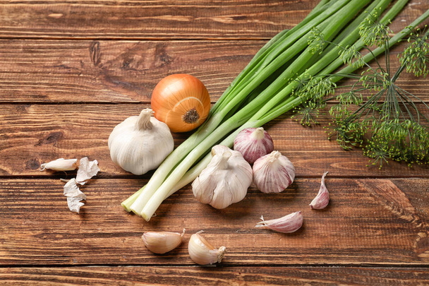 Fresh dill with garlic and onion on wooden background - Valokuva, kuva