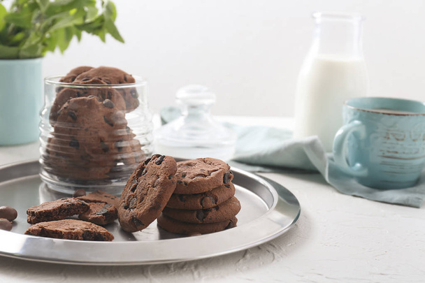 Bandeja de metal com deliciosos biscoitos de chocolate na mesa branca
 - Foto, Imagem