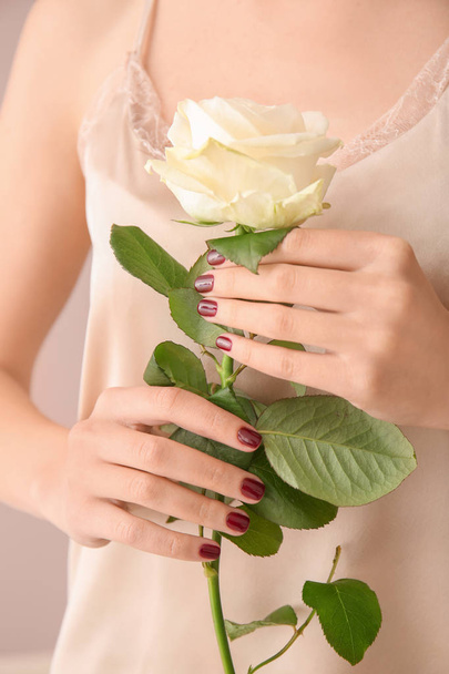 Young woman with beautiful manicure and rose, closeup - Фото, изображение