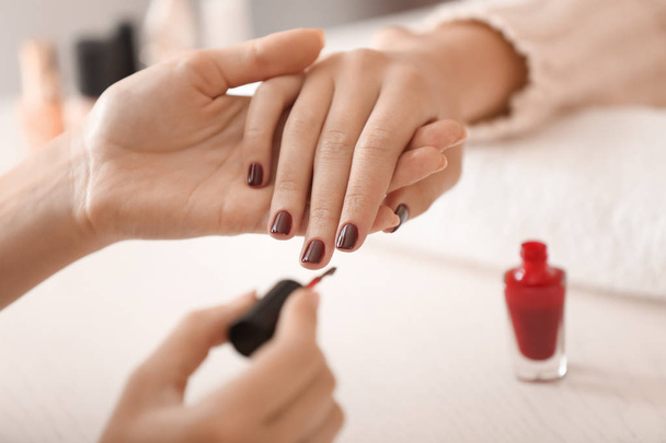 Young woman getting professional manicure in beauty salon - 写真・画像