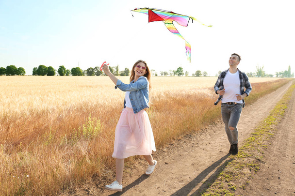 幸せな若いカップル凧フィールドに - 写真・画像