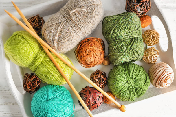 Plateau avec différents fils à tricoter et aiguilles sur la table
 - Photo, image