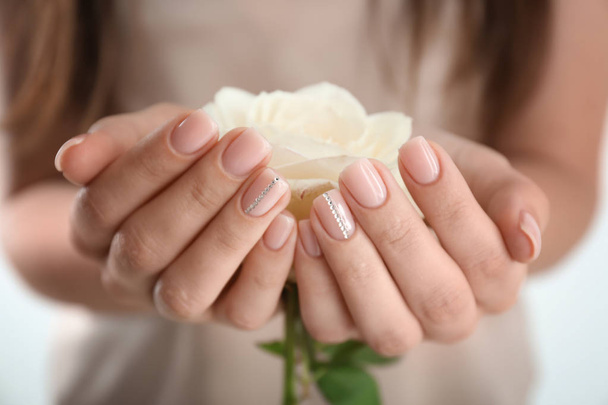 Young woman with beautiful manicure holding rose, closeup - Fotó, kép