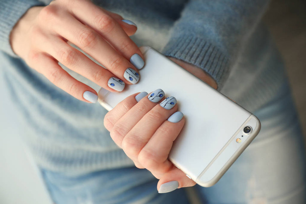 Jonge vrouw met mooie manicure telefoon, close-up houden - Foto, afbeelding