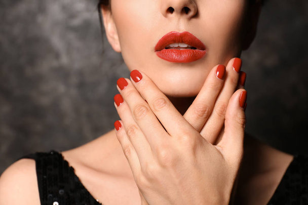 Young woman with beautiful manicure on dark background, closeup - Foto, imagen