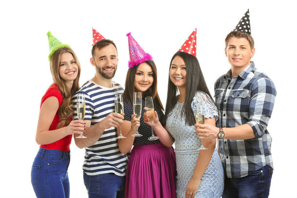 Młodzi ludzie w urodziny party czapki z kieliszków szampana na białym tle - Zdjęcie, obraz