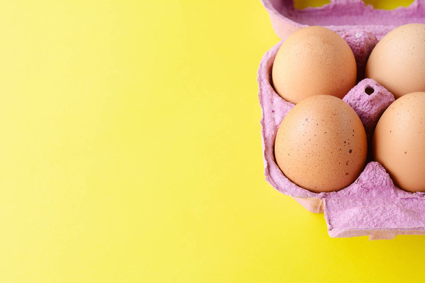 Top view of six brown eggs on box. Fresh food concept. Yellow background - Foto, afbeelding