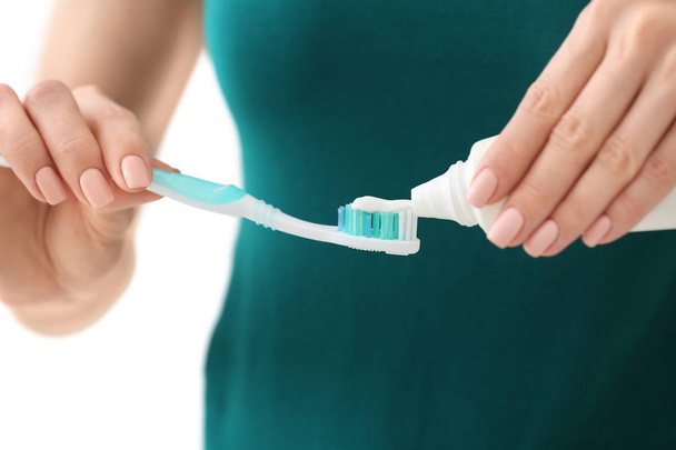 Young woman squeezing toothpaste on brush, closeup - Photo, Image
