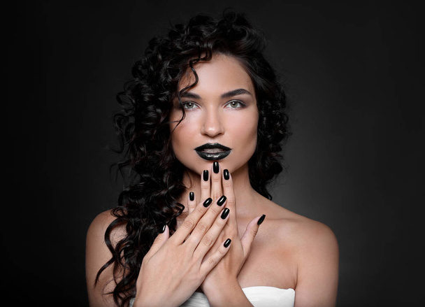 Fashionable young woman with black manicure on dark background - Foto, Bild