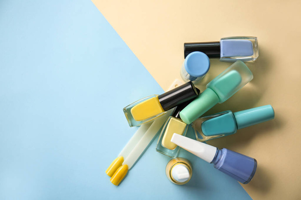 Бутылки лака и искусственных ногтей на цветном фоне
 - Фото, изображение