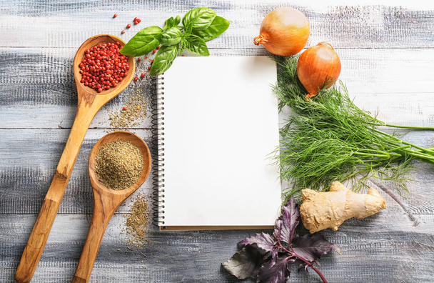 Composition with fresh herbs, spices and notebook on wooden background - Foto, afbeelding