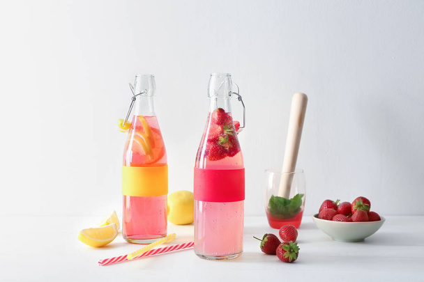 Natural lemonade with strawberry in glass bottles on table - Zdjęcie, obraz