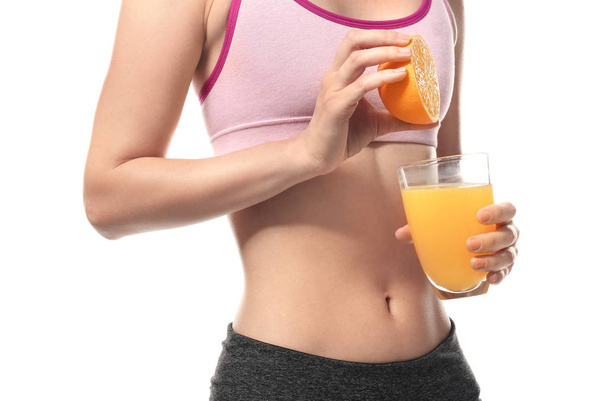 Frau mit einem Glas frischem Saft und einer halben Orange auf weißem Hintergrund - Foto, Bild