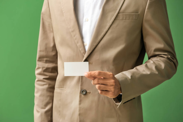 Man with business card on color background, closeup - Valokuva, kuva