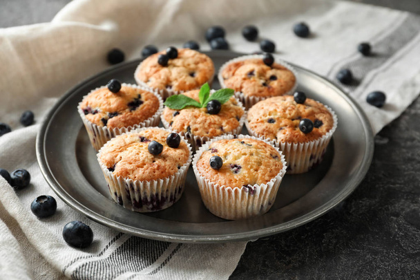 Piatto con gustosi muffin ai mirtilli in tavola - Foto, immagini