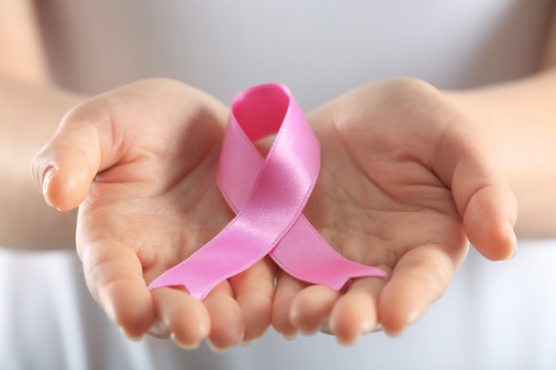 Beautiful woman holding pink ribbon, closeup. Breast cancer concept - Photo, Image