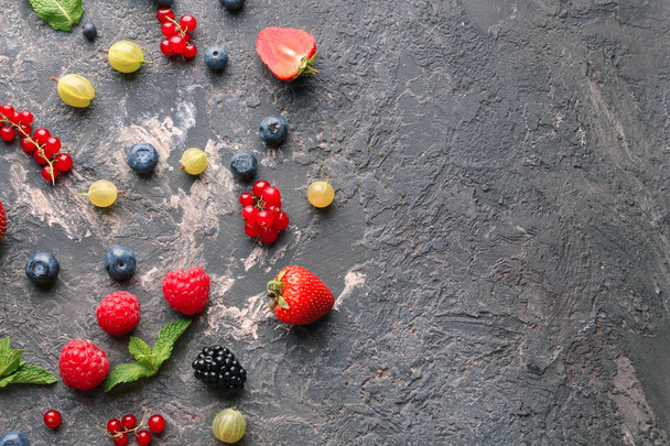 Delicious fresh berries on grey textured background - Fotoğraf, Görsel
