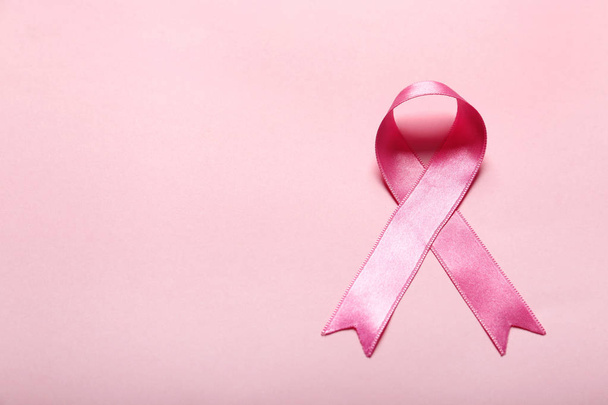Pink ribbon on color background. Breast cancer awareness concept - Photo, image