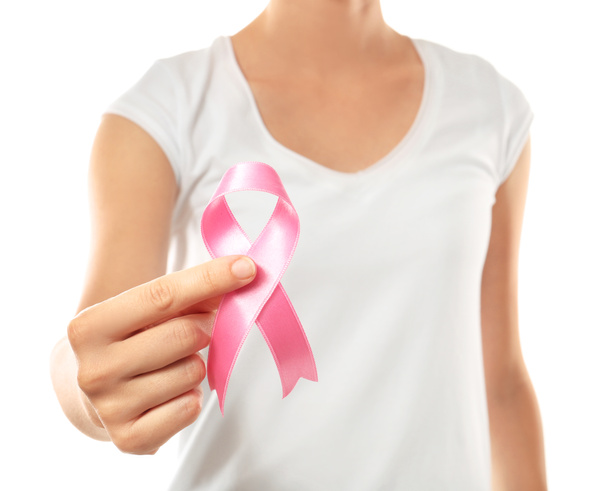 Mujer sosteniendo cinta rosa sobre fondo blanco, primer plano. Concepto de conciencia sobre el cáncer de mama
 - Foto, Imagen