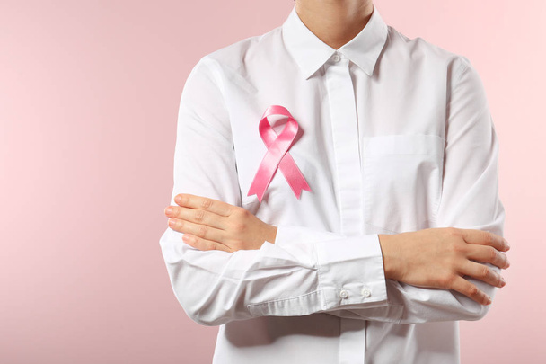 Γυναίκα με κορδέλα ροζ φόντο χρώμα, κινηματογράφηση σε πρώτο πλάνο. Έννοια συνειδητοποίηση καρκίνου του μαστού - Φωτογραφία, εικόνα