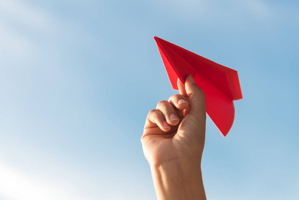 Femme Main tenant fusée en papier rouge avec fond bleu ciel. concept de liberté
. - Photo, image