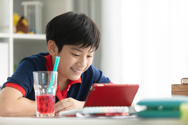 Asian cute boy watching on tablet computer with smile face  at home. - Photo, Image