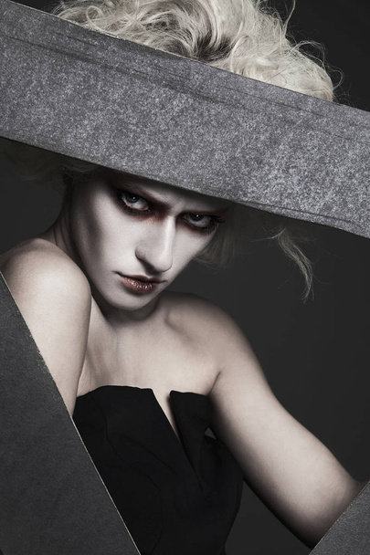 halloween style girl with white skin and hair with clown make-up posing in the studio.psycho woman image - Fotó, kép