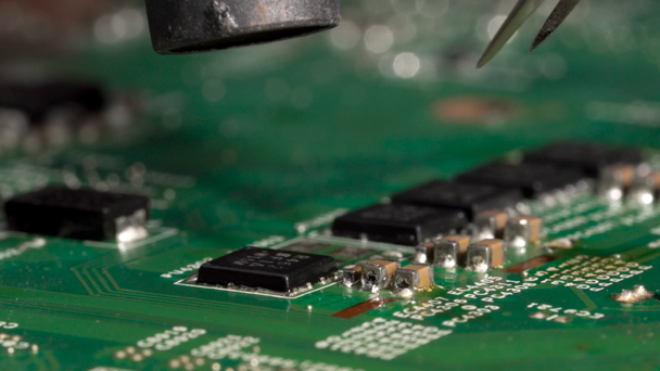 Desolder del microprocesador de circuito integrado minúsculo de la placa de circuito impresa usando la estación de soldadura del aire caliente. Primer plano macro
. - Imágenes, Vídeo