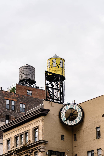 Vista ad angolo basso delle torri d'acqua e dell'orologio contro il cielo a New York
 - Foto, immagini