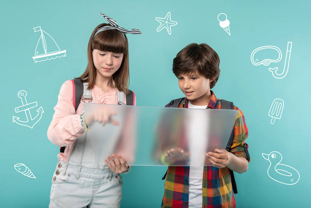 Confident kids standing with a transparent device and looking at the screen - Photo, Image