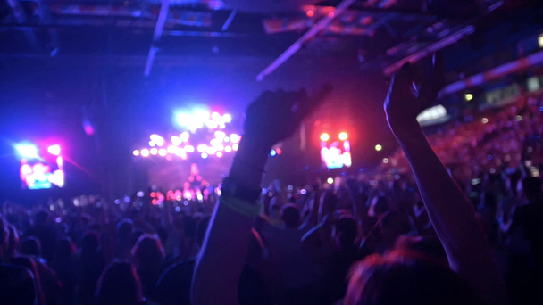 As pessoas levantam as mãos num concerto de rock, em câmara lenta.
 - Filmagem, Vídeo