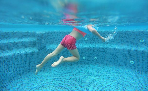 Legs of child girl view from under water. - Foto, Bild