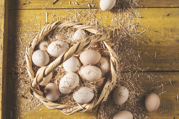 Szalma kosár friss nyers tojás - Fotó, kép